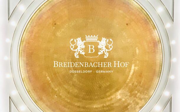 Aufnahme der goldenen Kuppeldecke von Breidenbacher Hof und Logo des Hotels