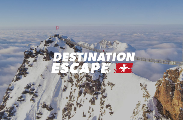 Swiss mountains above a sea of clouds and the Destination Escape logo